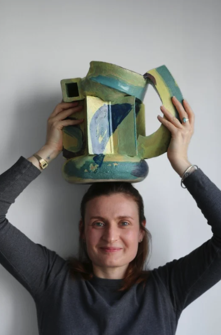 Agathe Rottier holding a ceramic artwork